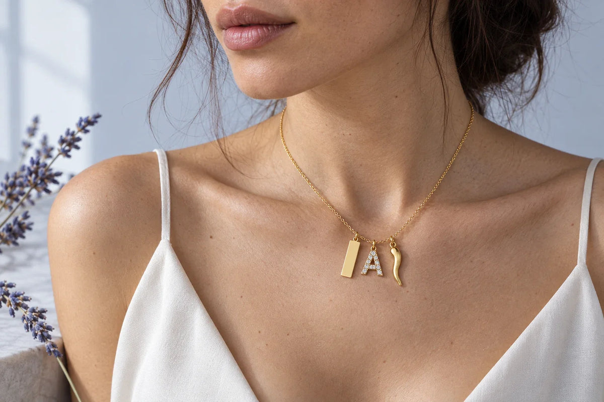Selezione di ciondoli in argento 925 disposti su superficie chiara, collana personale con charm